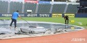 빗물 걷으며 경기 준비