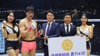 로드FC 한우영에게 승리 기념 트로피 수여하는 김용빈 국제로타리 공공이미지 홍보대사-김명준 미래종합건설 총재