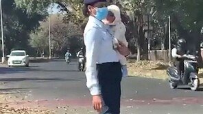 아기 안고 교통정리 나선 경찰…“슬픈 현실”vs“위대한 엄마”