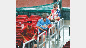 갑자기 쏟아진 비에… 글러브 안 젖게 감춰야지