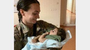 철조망 넘어온 아기 보살피는 미군들[청계천 옆 사진관]