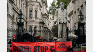 “유전 시추 중단하라”… 기름 뒤집어쓴 존슨 조형물