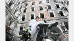 러軍 포격받은 건물 배경으로 결혼 기념촬영