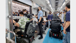 사다리 목에 걸고 지하철 출입문 막아선 전장연[청계천 옆 사진관]