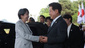 李, 안동 호텔 입구서 다카이치 영접…“시골 소도시 오시느라 고생”