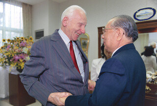 이케다 회장(오른쪽)이 노벨평화상을 받은 영국의 핵물리학자 조지프 로트블랫을 2000년 2월 일본 오키나와에서 만나 손을 맞잡고 있다. 세이쿄신문