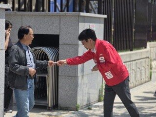 5월 13일 오전 평택 고덕읍 함박초등학교 앞에서 유의동 후보가 학부모 참관수업을 마치고 나오는 유권자들에게 명함을 나눠주고 있다. 박세준 기자
