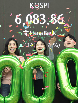 코스피가 사상 처음 6000을 돌파하며 6083.86으로 장을 마감한 2월 25일 서울 중구 하나은행 본점 딜링룸에서 직원들이 축하 행사를 하고 있다. 뉴스1