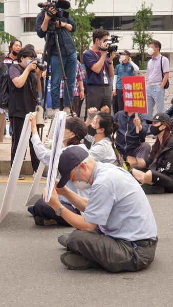 한 노인이 부동산 촛불집회 현장에서 바닥에 앉은 채 휴식을 취하고 있다. [박해윤 기자]