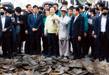 이재명 대표(앞줄 가운데)가 자신의 공직선거법 위반 사건 항소심 선고 다음 날인 3월 27일 오전 산불로 전소된 경북 의성군 고운사를 방문해 피해 현장을 살펴보고 있다.  뉴스1

