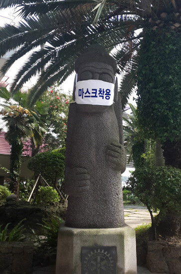 제주국제공항 청사를 나오면 마스크를 착용한 대형 돌하르방이 관광객의 주의를 환기시킨다. [배수강 기자]