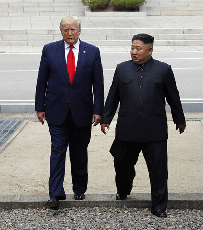 2019년 6월 30일 도널드 트럼프 미국 대통령과 김정은 북한 국무위원장이 판문점 군사분계선 북측 지역에서 만나 인사한 뒤 남측 지역을 향해 이동하고 있다. [뉴시스]