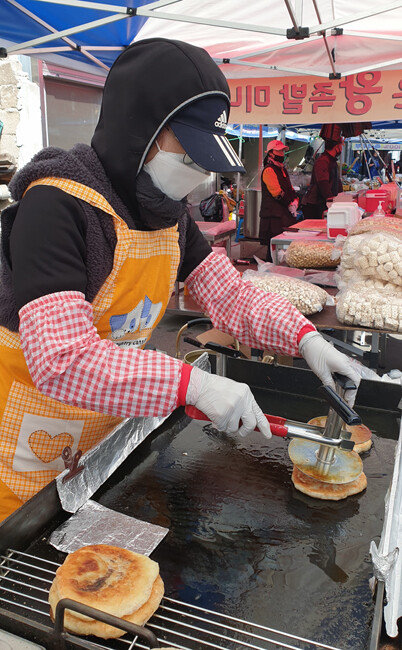 마스크를 끼고 호떡을 굽는 모습. 
