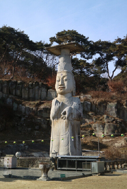 은진미륵은 다른 불상에 비해 머리가 크다. 머리 위에는 불상의 장식인 보개가 얹혀 있는데, 보개와 얼굴의 길이가 몸길이와 비슷할 정도다. [문화재청]