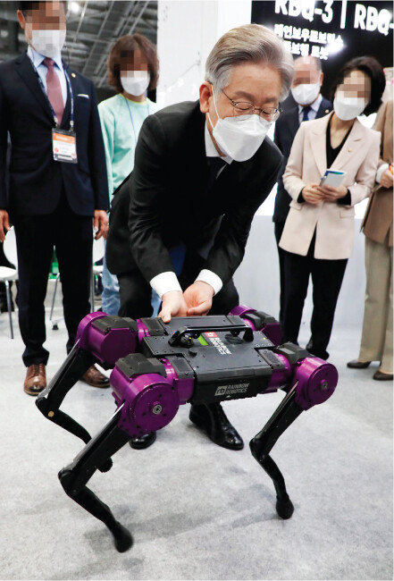 더불어민주당 이재명 대선 후보(가운데)가 지난해 10월 28일 경기 고양시 킨텍스에서 열린 ‘2021 로보월드’에 참석해 사족보행 로봇을 살펴보고 있다. [동아DB]