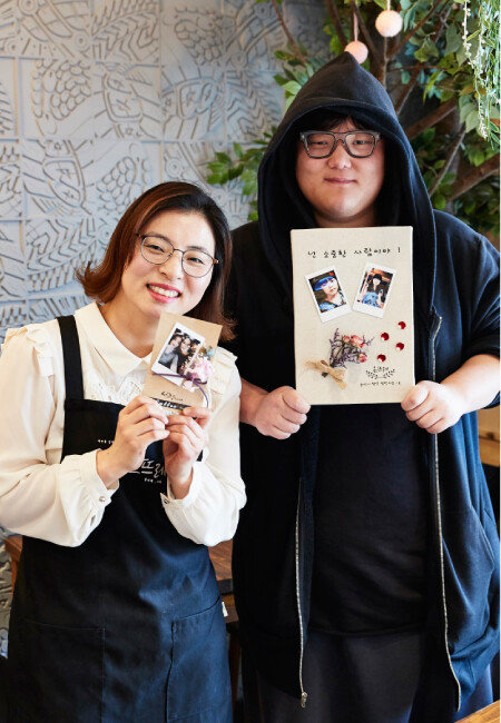 청년 챌린지숍 사업에 참여하고 있는 청년창업인 김수진(왼쪽), 김현빈 씨가 협업해 만든 폴라로이드 플라워 액자를 들고 포즈를 취했다. [홍중식 기자]