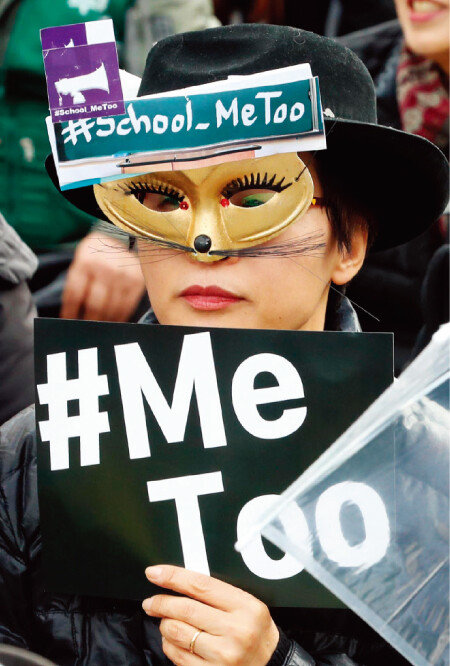 3월 8일 오후 서울 종로구 광화문광장에서 열린 3·8 세계 여성의 날 전국여성노동자대회에서 가면을 쓴 한 참가자가 미투 손팻말을 들고 있다. [뉴시스]