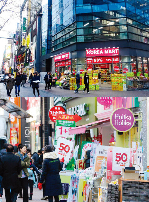 명동 3가 MCM 매장 앞에 위치한 대형마트(위). 지난해 2017년 12월 24일 오후 명동 거리의 가게마다 ‘반값 세일’ 피켓을 들고 호객행위를 하고 있다. [구자홍 기자]