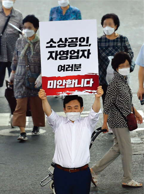 원희룡 전 제주도지사가 8월 19일 대구 중구 서문시장을 찾아 ‘소상공인, 자영업자 여러분 미안합니다’라는 글귀가 적힌 손팻말을 든 채 사과하고 있다. [뉴시스]