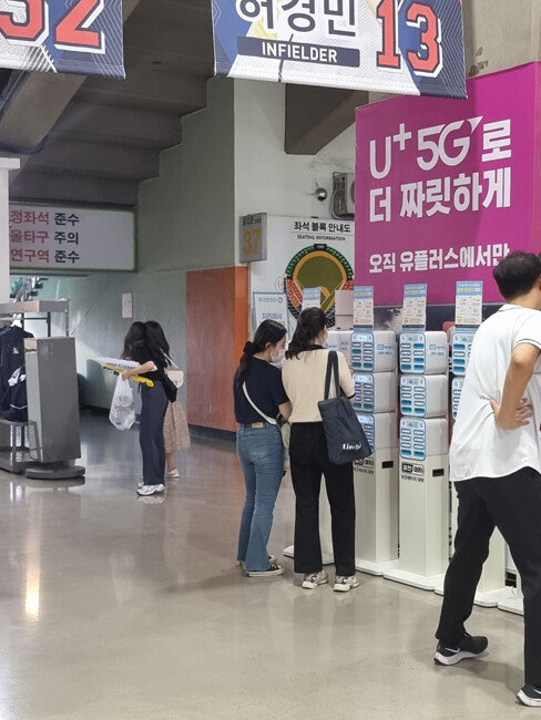 야구팬들이 서울 송파구 잠실야구장에 설치된 보조배터리 대여 서비스 ‘충전돼지’를 사용하고 있다. {㈜백퍼센트]