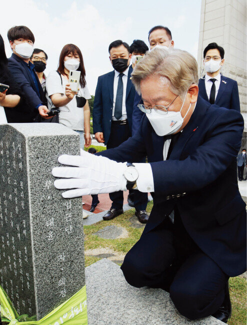 이재명 경기도지사가 5월 18일 광주 북구 국립5 ·18민주묘지를 찾아 5 ·18 최초 희생자인 김경철 열사의 묘비를 어루만지고 있다. [뉴스1]