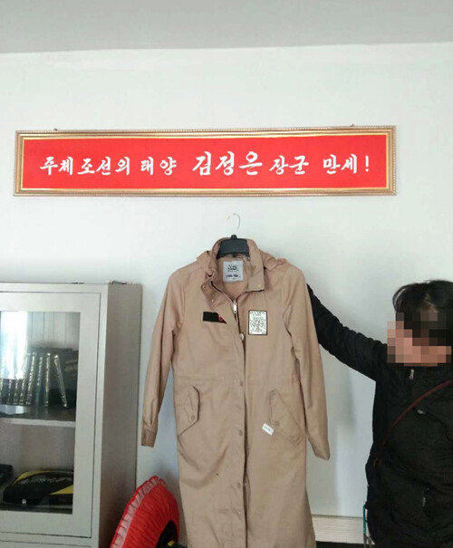 북한 근로자가 평양의 한 공장에서 해외 유명 브랜드 의류를 들고 있다. 