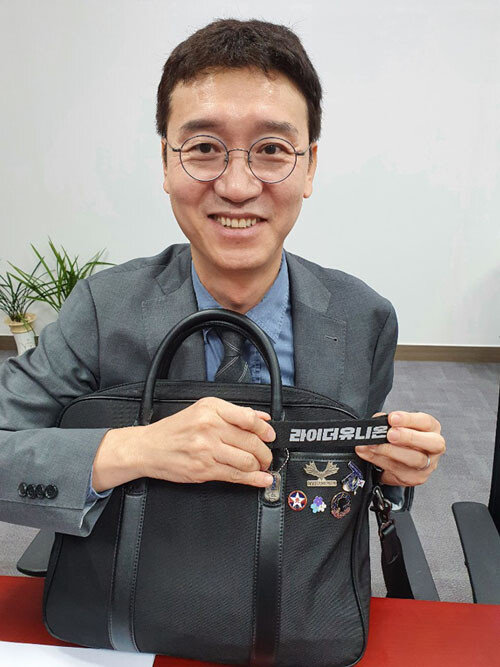 9월 23일 서울 영등포구 국회의원회관 사무실에서 김웅 의원이 ‘라이더유니온’이 선물한 장식품을 보여주며 웃고 있다. [김우정 기자]