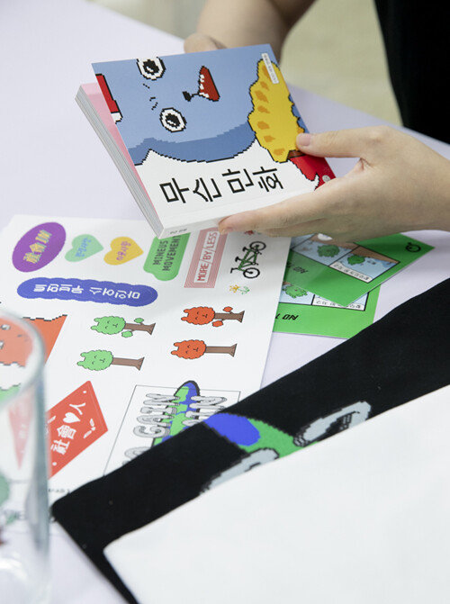 단행본 ‘무슨 만화’를 잡고 있는 OOO 작가의 손. 작가의 요구에 따라 손만 사진에 담았다. [지호영 기자]