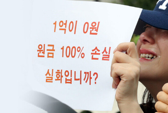 DLF 투자 피해자가 9월 27일 서울 여의도 국회 앞에서 해당 은행 국정조사를 요구하며 손팻말을 들고 있다. [뉴시스]