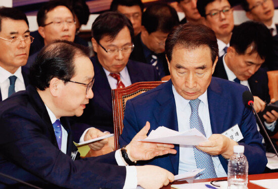 10월 10일 오전 국회 국토교통위원회 국정감사에서 이강래 한국도로공사 사장(오른쪽)과 이강훈 부사장이 자료를 주고받고 있다. [양회성 동아일보 기자]