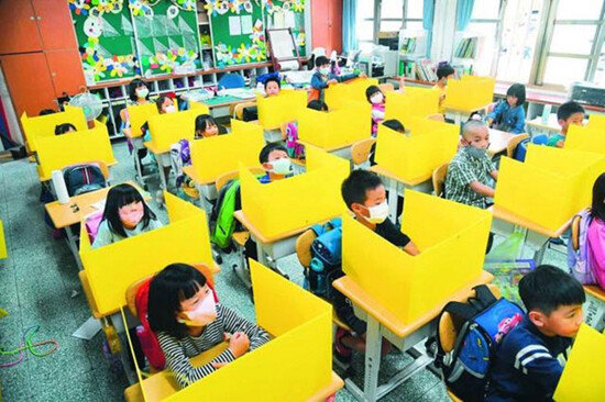 대만 초등학생들이 노란색 개인용 칸막이를 책상에 놓은 채 수업하고 있다. [CNA]