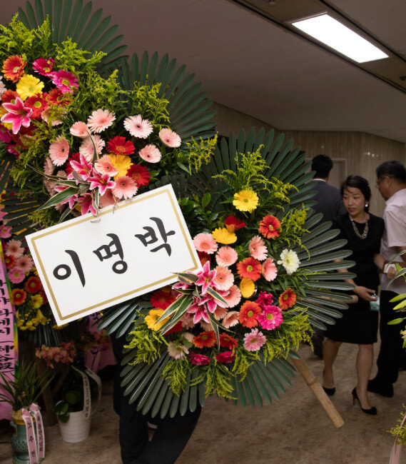 6월 10일 서울 여의도 국회도서관에서 열린 ‘평등의 역습’ 북콘서트 행사장으로 이명박 전 대통령이 보낸 화환이 들어가고 있다. [박해윤 기자]