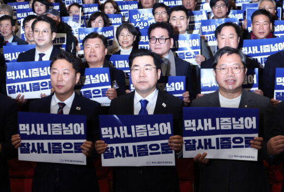 박찬대 더불어민주당 원내대표가 2월 23일 오후 서울 여의도 국회 의원회관에서 열린 먹사니즘 전국 네트워크 발대식에서 참석자들과 손피켓을 들고 기념촬영을 하고 있다. 뉴스1