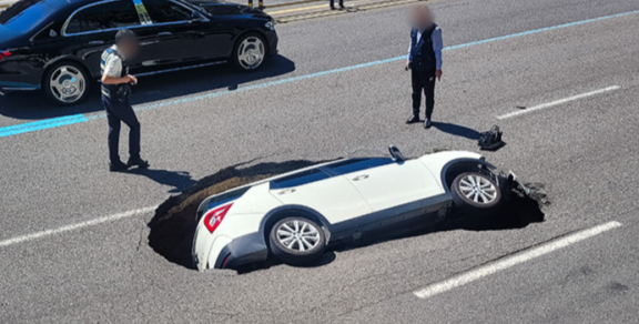 2024년 8월 29일 서울 서대문구 연희동 성산로 모래내 고가차로 부근의 한 차도에서 발생한 싱크홀에 승용차가 빠져 있다. 뉴스1