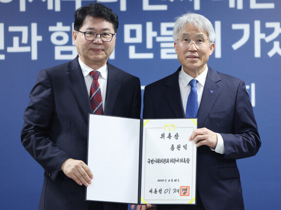 이한주 국정기획위원회 위원장(왼쪽)이 6월 16일 서울 종로구 정부서울청사 창성동 별관에서 열린 출범식에서 외교안보분과장을 맡은 홍현익 세종연구소 명예연구위원에게 위촉장을 수여한 뒤 기념촬영을 하고 있다. 공동취재