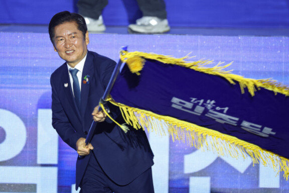 정청래 더불어민주당 신임 당대표가 8월 2일 경기 고양시 킨텍스에서 열린 제2차 임시전국당원대회에서 당기를 흔들고 있다. 뉴스1 