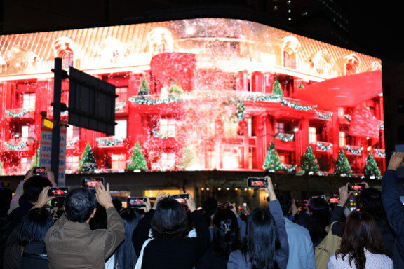 2024년 11월 1일 서울 중구 신세계백화점 본점 앞을 찾은 시민들이 외벽에 설치된 LED 사이니지 ‘세계스퀘어’에서 펼쳐진 미디어 파사드를 휴대전화로 촬영하고 있다. 뉴스1