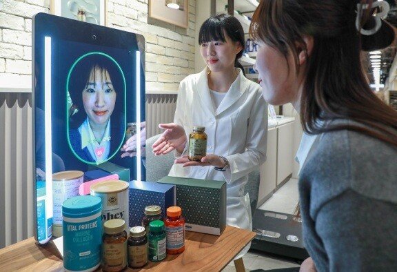 현대백화점 목동점 ‘네슬레 헬스사이언스 스토어’에서 고객이 비접촉식 건강 진단 기기 ‘아누라 매직미러’를 체험해보고 있다. 현대백화점그룹 제공