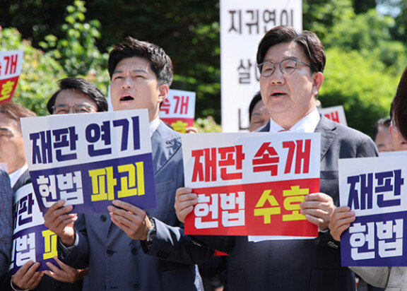 국민의힘 김용태 비상대책위원장(왼쪽)과 권성동 전 원내대표가 6월 11일 서울 서초구 서울고법 앞에서 재판부의 기일 추후 지정 결정을 비판하는 의원총회를 열고 구호를 외치고 있다. 뉴시스