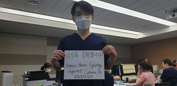 대구경북2생활치료센터 봉사자들이 환자와 의료진을 향한 격려 메시지를 들어 보이고 있다.  
