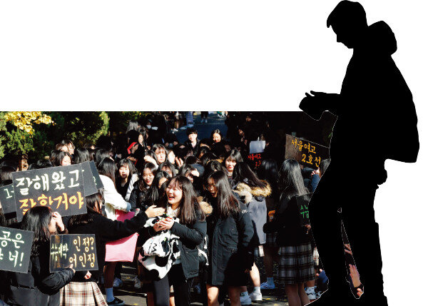 23일 고사장에 들어가는 수험생들이 후배들의 응원을 받고 있는 모습.[동아 DB]
