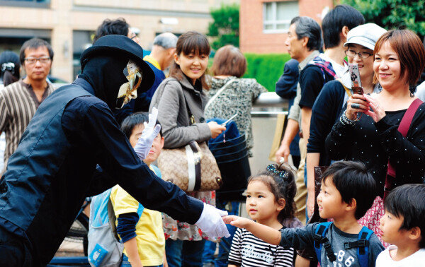 일본 도쿄에서 엄마와 아이들이 퍼포먼스를 펼치는 아티스트와 함께 즐거운 한때를 보내고 있다. [신화  =  뉴시스]