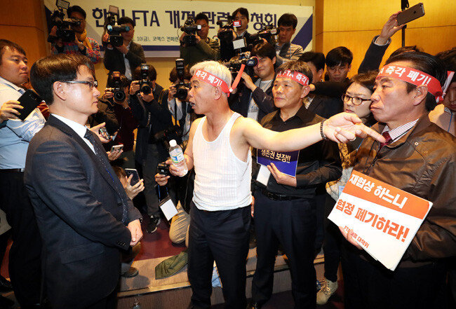 농민단체 관계자들이 11월 10일 서울 강남구 코엑스에서 열린 ‘한미FTA 개정 협상을 위한 공청회’에서 강성천 산업통상자원부 차관보(왼쪽)에게 항의하고 있다.[최혁중 동아일보 기자]