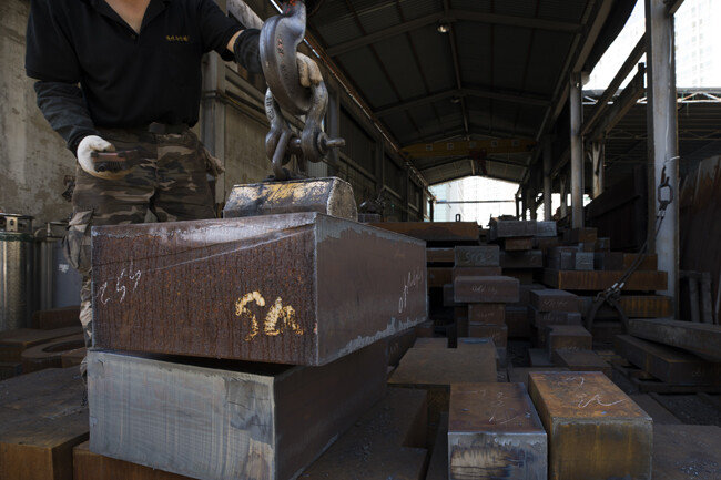 무거운 철근을 자석으로 들어 올리는 모습.