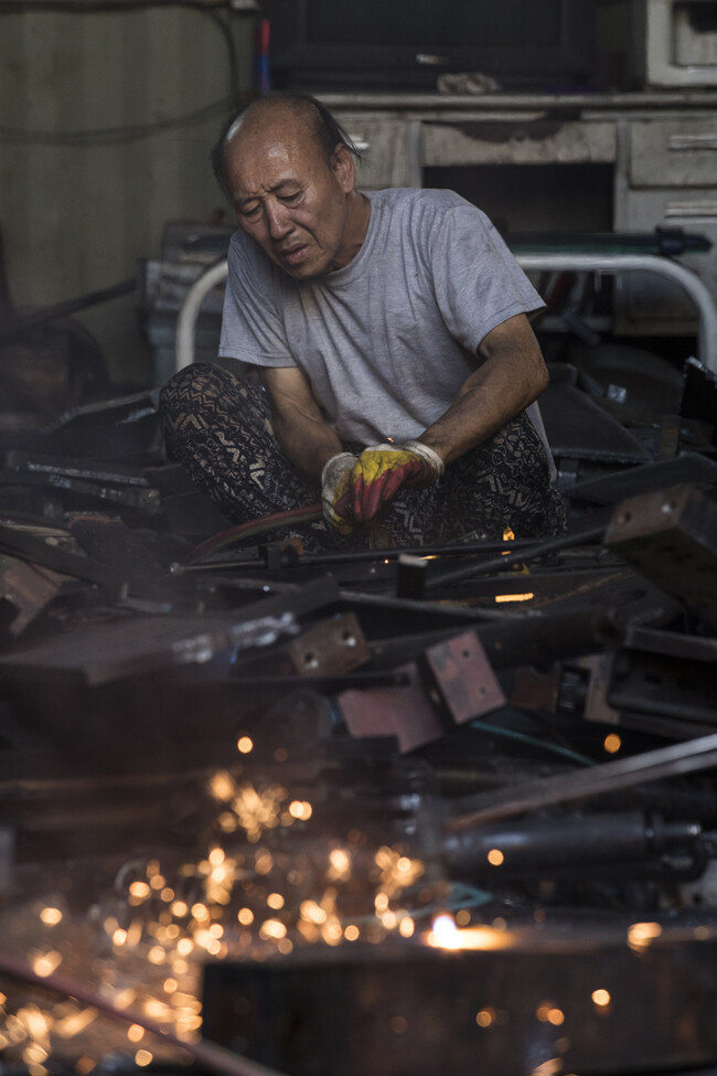 무더운 여름 뜨거운 열기를 견디며 쇠를 자르고 있다.