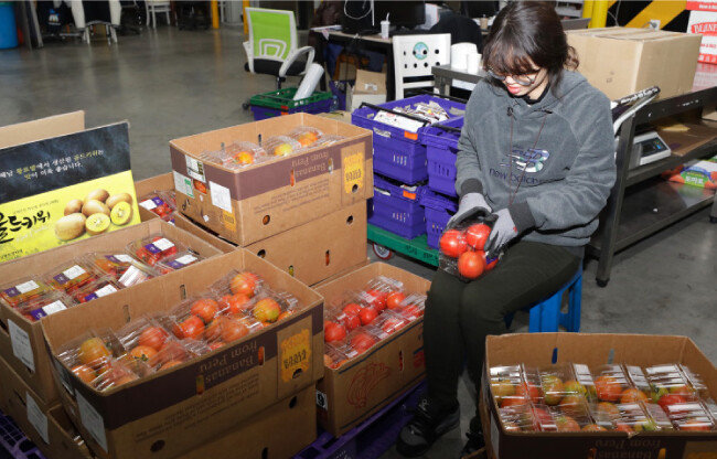 방울토마토 같은 신선식품에 하자가 없는지 일일이 확인하는 검수 담당 직원. [박해윤 기자]