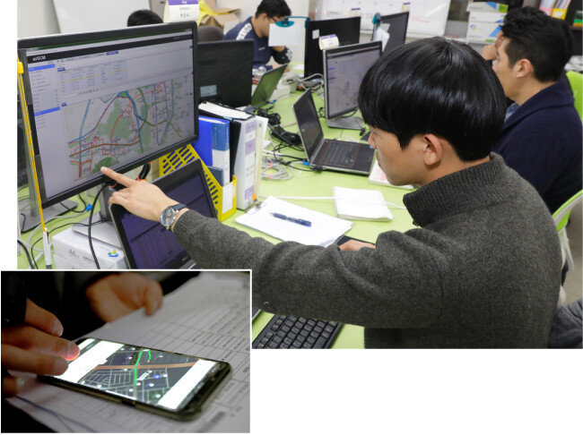 밤 11시 고객 주문이 마감되자마자 최적의 배달 경로를 짜는 마켓컬리 직원들. 한 배송기사가 스마트폰 앱으로 전송된 배달 경로를 확인하고 있다(작은 사진). [박해윤 기자]