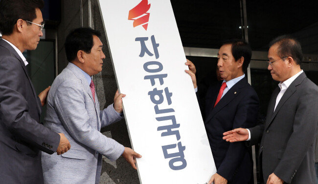7월 11일 김성태 자유한국당 당대표권한대행 겸 원내대표(오른쪽에서 두 번째) 등이 여의도 자유한국당 구당사에서 현판을 떼어내고 있다. 자유한국당은 이날 영등포로 당사를 옮겼으나 여의도연구원은 구당사에 남았다. [뉴시스]