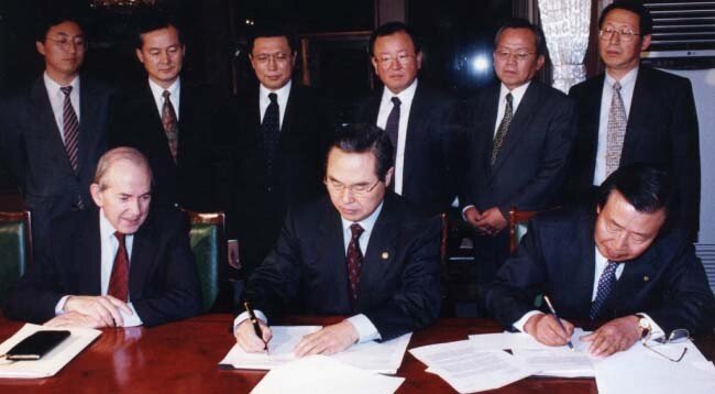 1997년 12월 3일 임창렬 경제부총리(가운데)와 이경식 한국은행 총재(오른쪽)가 국제통화기금(IMF) 미셸 캉드시 총재가 지켜보는 가운데 IMF국제금융 합의문서에 서명하고 있다.