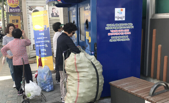 한 주민이 상당한 분량의 재활용품을 마대에 가득 담아와서 인공지능 재활용품수거기 네프론에 투입하고 있다. [김규훈]
